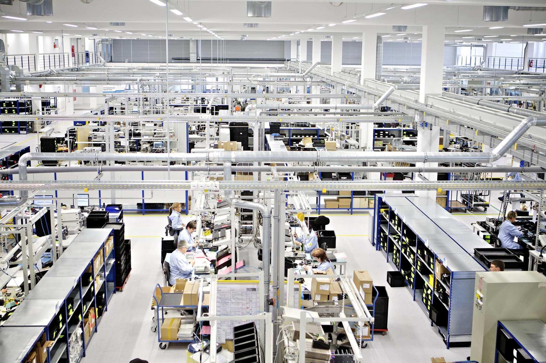 Production hall from inside with several employees sitting on their workstations